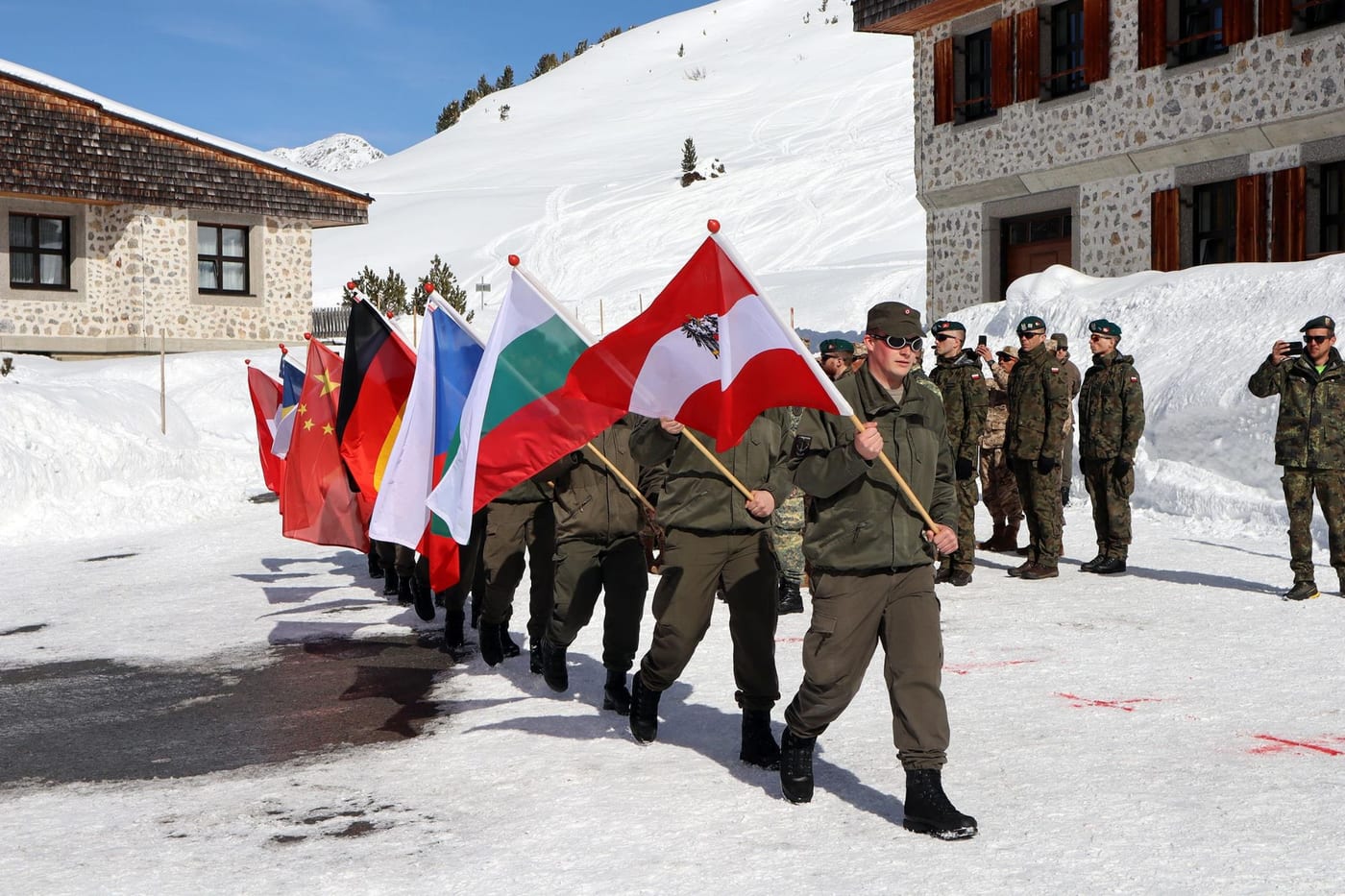 Le delegazioni internazionali sfilano con le rispettive bandiere in un raduno della International Federation of Mountain Soldiers.